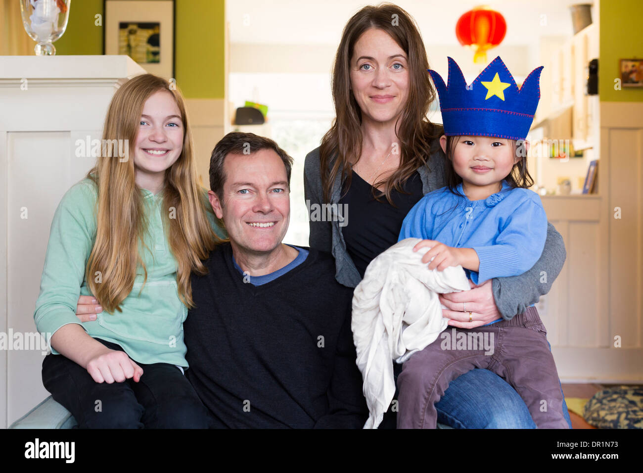 Family smiling together in living room Banque D'Images