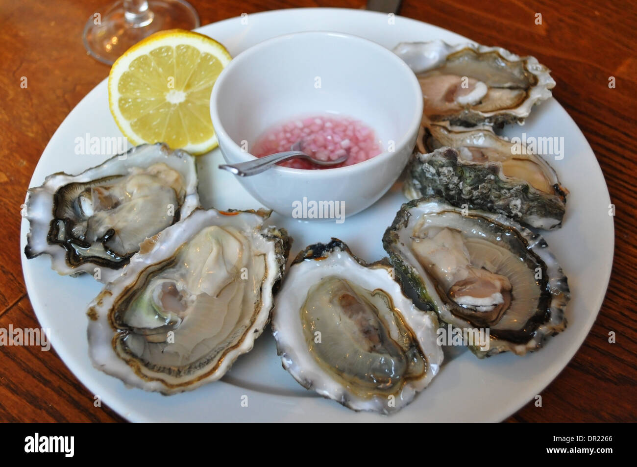 Une demi-douzaine d'huîtres servies avec du citron et une mignonette vinaigre échalote dans un restaurant de Londres Banque D'Images