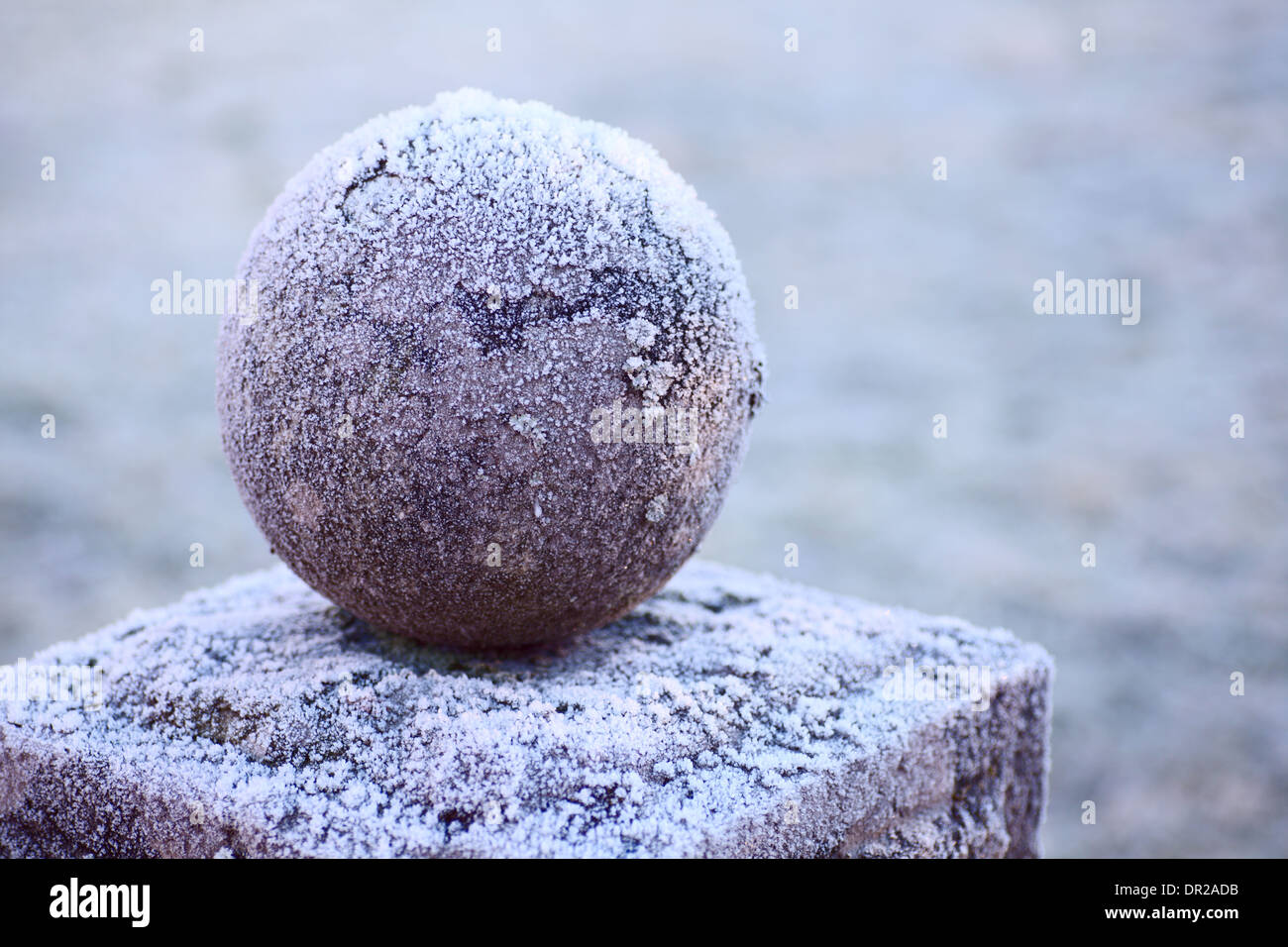 Balle sur un piédestal de granit recouvert de givre Banque D'Images