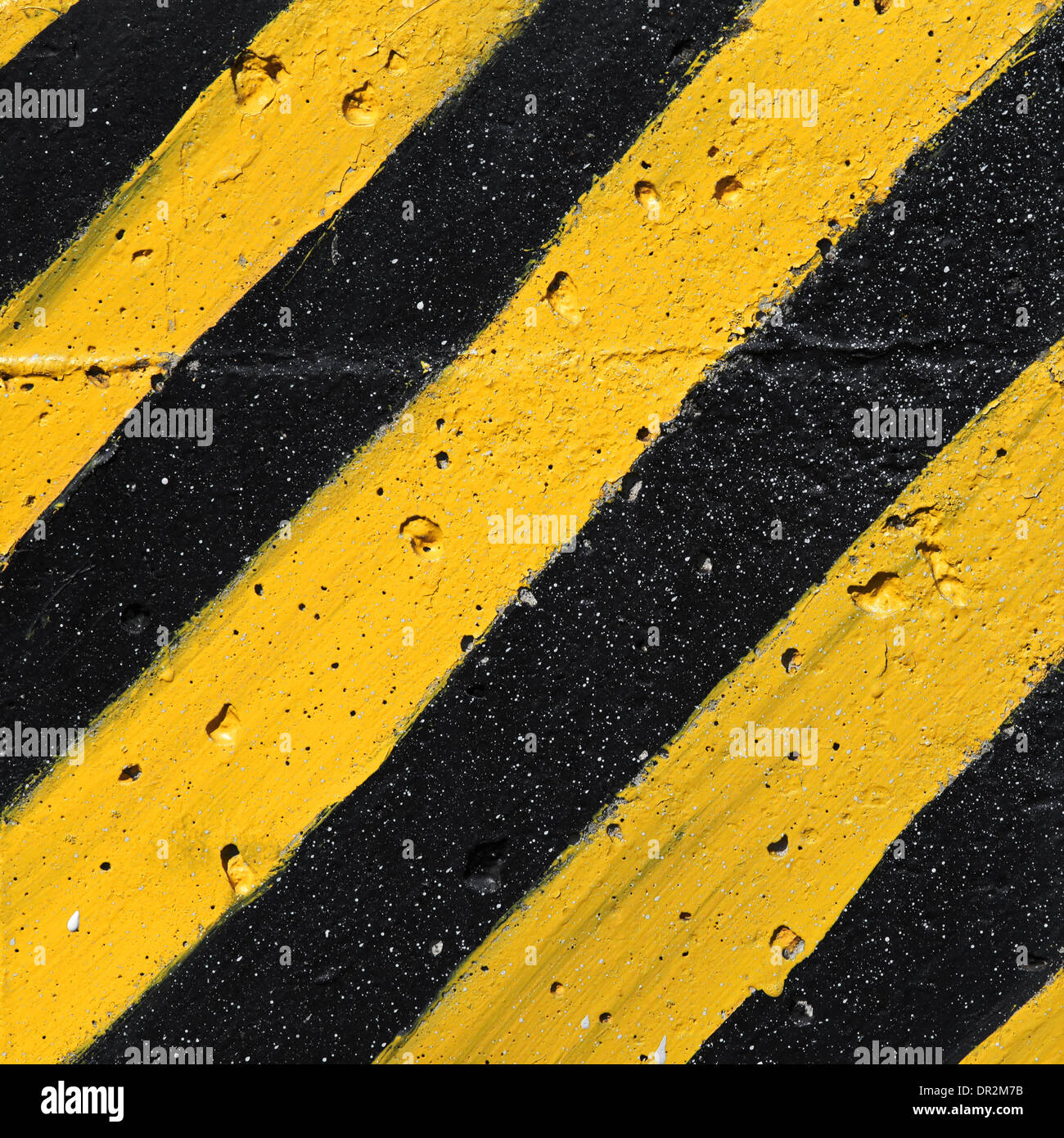 Rayé jaune et noir attention sur mur de béton Banque D'Images