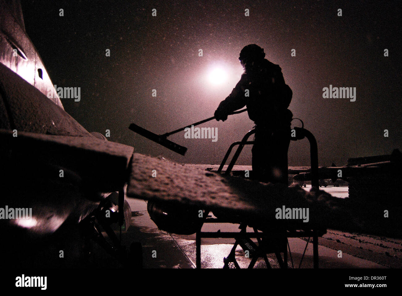 Pilote américain efface la neige de un F-16 Fighting Falcon, l'Afghanistan. Banque D'Images