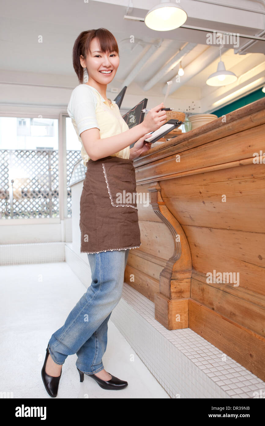Jeune femme travaillant au café Banque D'Images