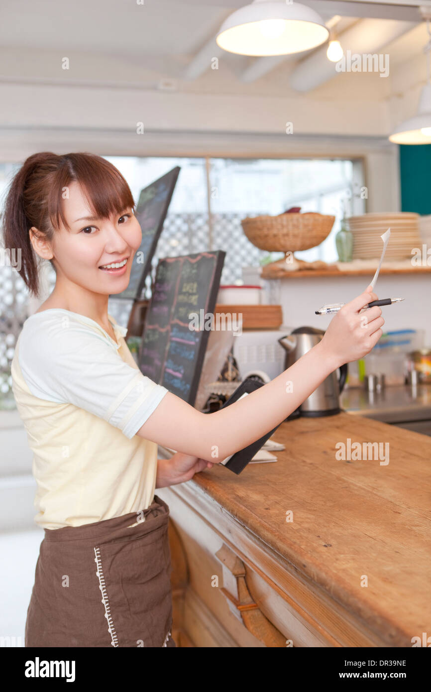 Jeune femme travaillant au café Banque D'Images