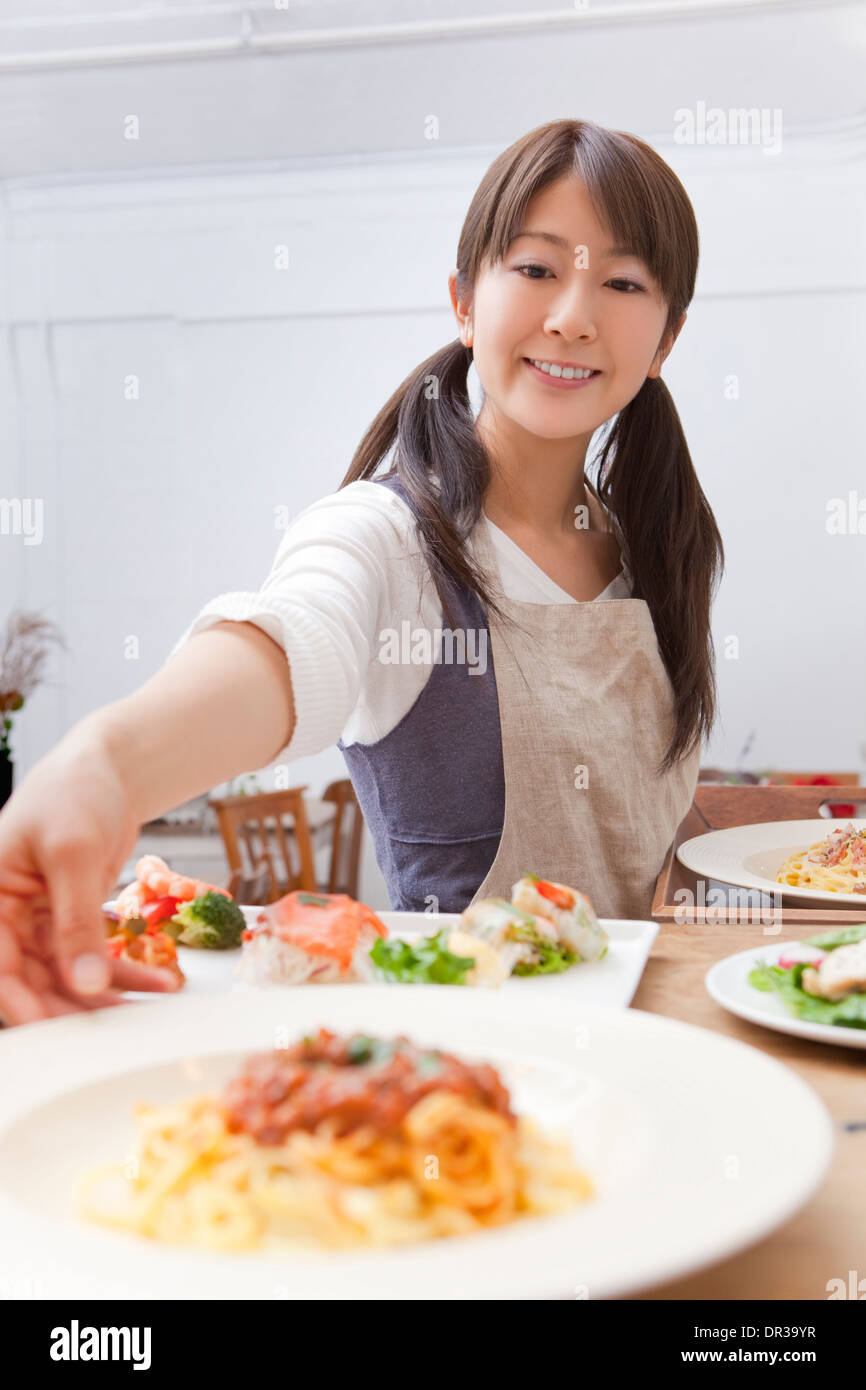 Jeune femme travaillant au café Banque D'Images