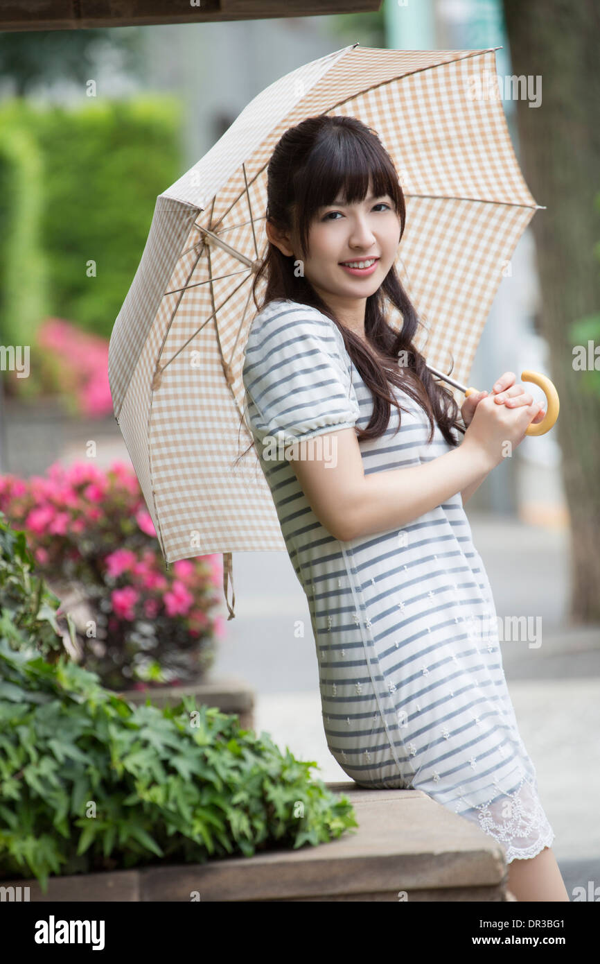 Jeune femme tenant un parasol Photo Stock - Alamy