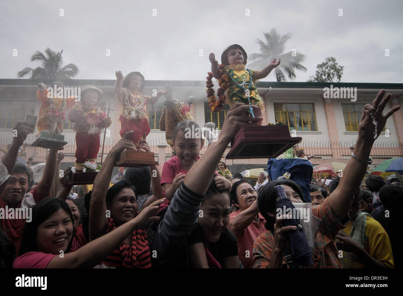 Manille, Philippines. 19 Jan, 2014. Les catholiques philippins élever leur Santo Nino statues qu'ils sont pulvérisés avec de l'eau bénite pendant la fête de Santo Nino dans une église dans le quartier pauvre de Tondo à Manille, Philippines, le 19 janvier 2014. Le festival est célébré chaque troisième dimanche de janvier, qui rend hommage à l'Enfant Jésus plus communément connue sous le nom de ''Santo Nino'' pour les catholiques philippins.Photo : Ezra Acayan/NurPhoto Acayan Crédit : Ezra/NurPhoto ZUMAPRESS.com/Alamy/Live News Banque D'Images