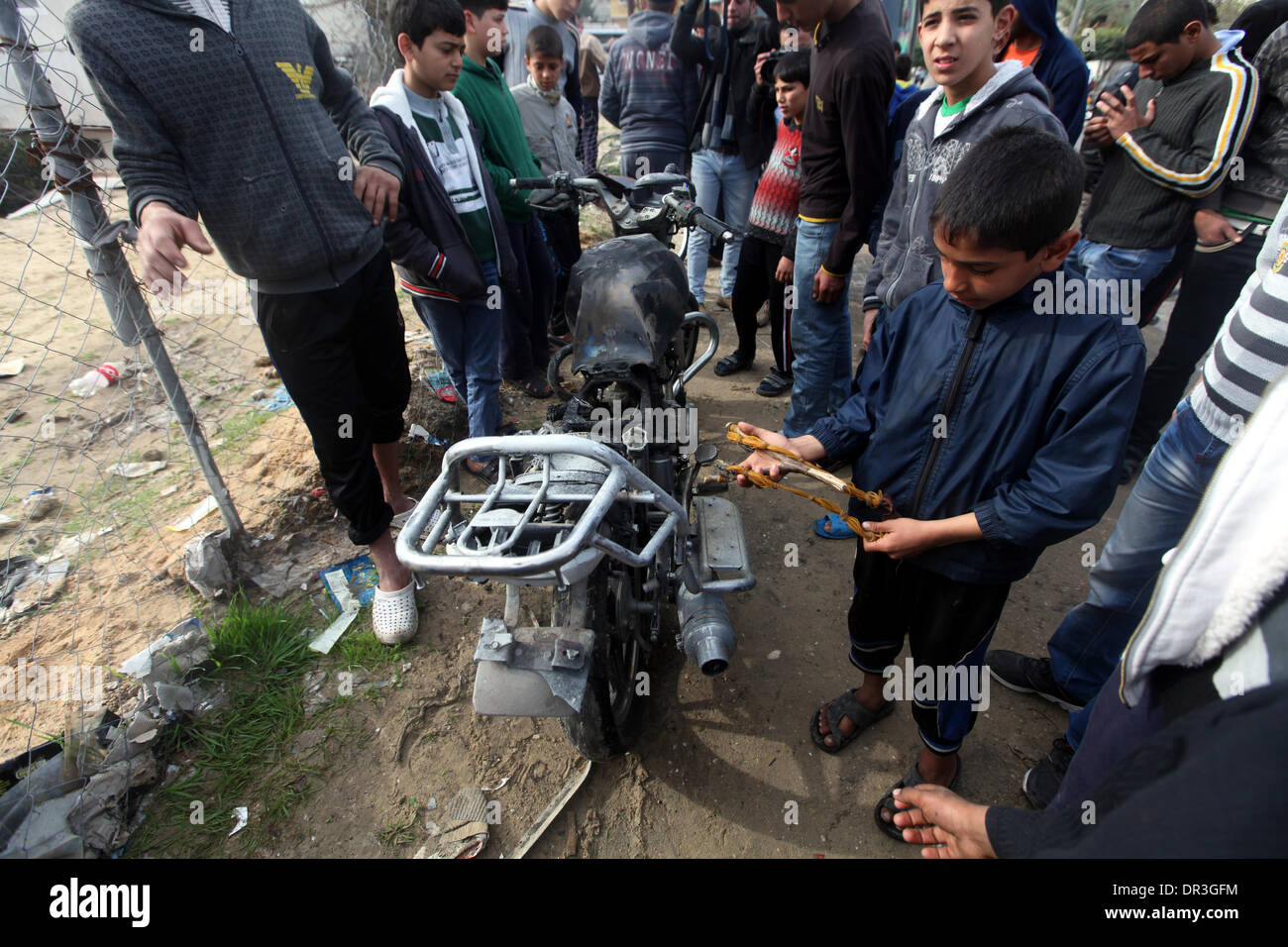 Gaza, Territoires palestiniens. 19 Jan, 2014. Palestiniens regardez une motocyclette, qui selon des témoins a été touché dans un raid aérien israélien, dans le nord de la bande de Gaza le 19 janvier 2014. Israël a effectué une frappe aérienne sur dimanche contre un militant de Gaza qu'il a blâmé pour les roquettes la semaine dernière. Les médecins palestiniens a déclaré que deux personnes, dont un garçon de 12 ans, ont été blessés. Credit : Moemen Faiz/NurPhoto ZUMAPRESS.com/Alamy/Live News Banque D'Images