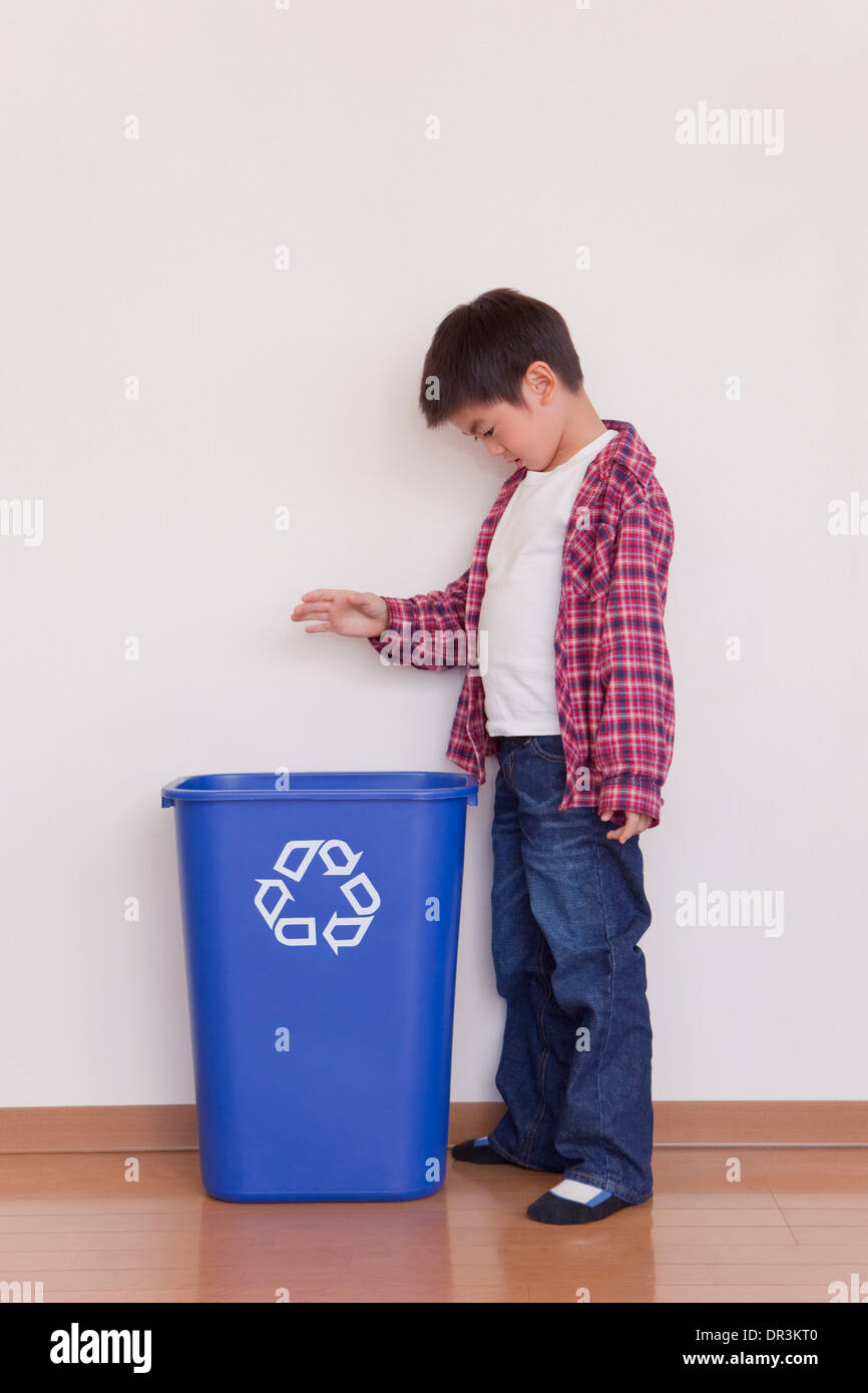 La mise en bouteille en plastique Boy recycling bin Banque D'Images