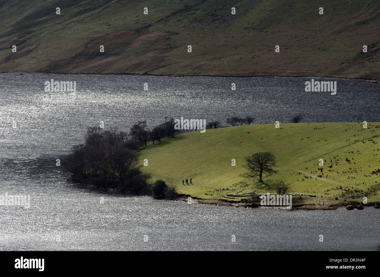 Un groupe lointain marche sur les rives du lac, Crummock Water District, Cumbria, Angleterre. Banque D'Images