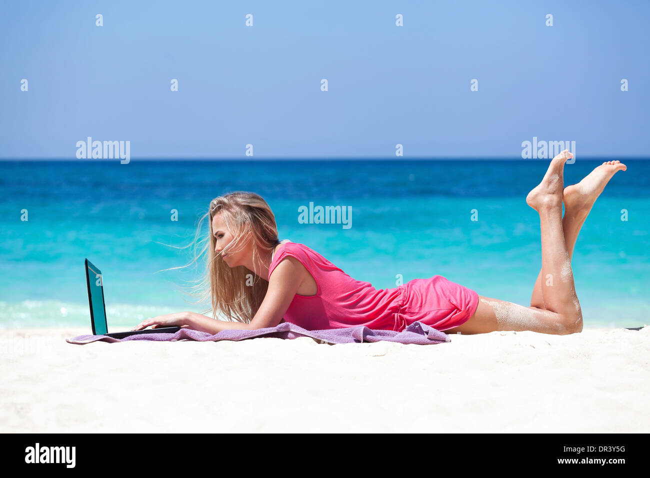 Fille blonde avec un ordinateur portable sur la plage tropicale, freelance concept. Banque D'Images