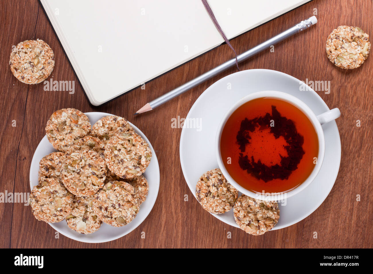 Tasse de thé avec des biscuits de sésame et d'un ordinateur portable Banque D'Images