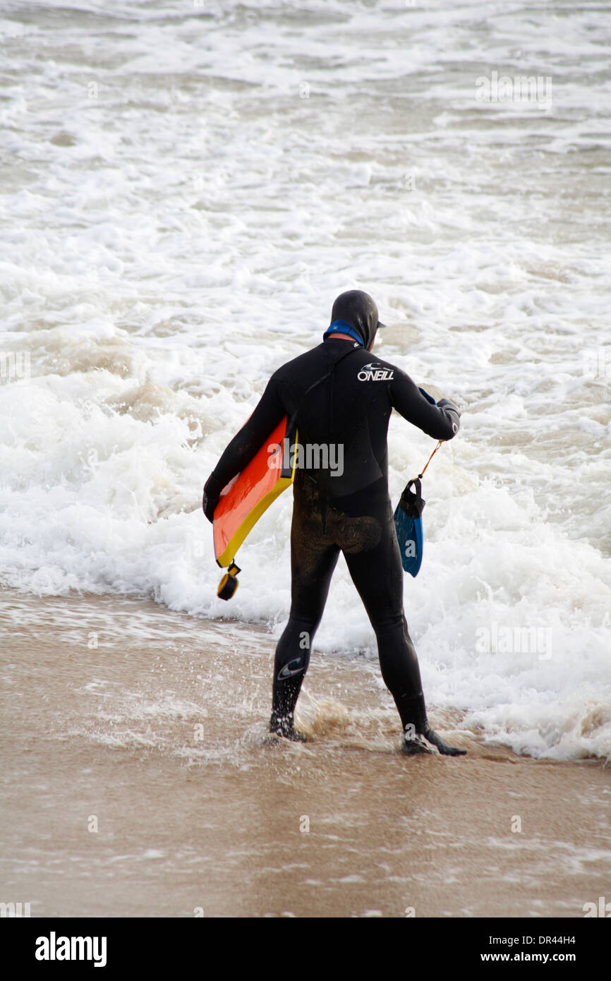 Surfer à la plage de Bournemouth en Janvier Banque D'Images
