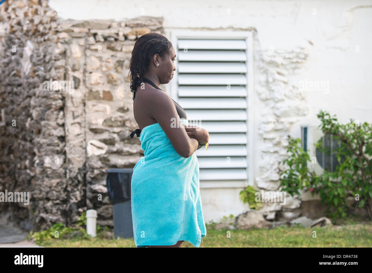 Une jeune femme afro-américaine en maillot de bain se tient dans une serviette après la baignade dans les Caraïbes. Banque D'Images