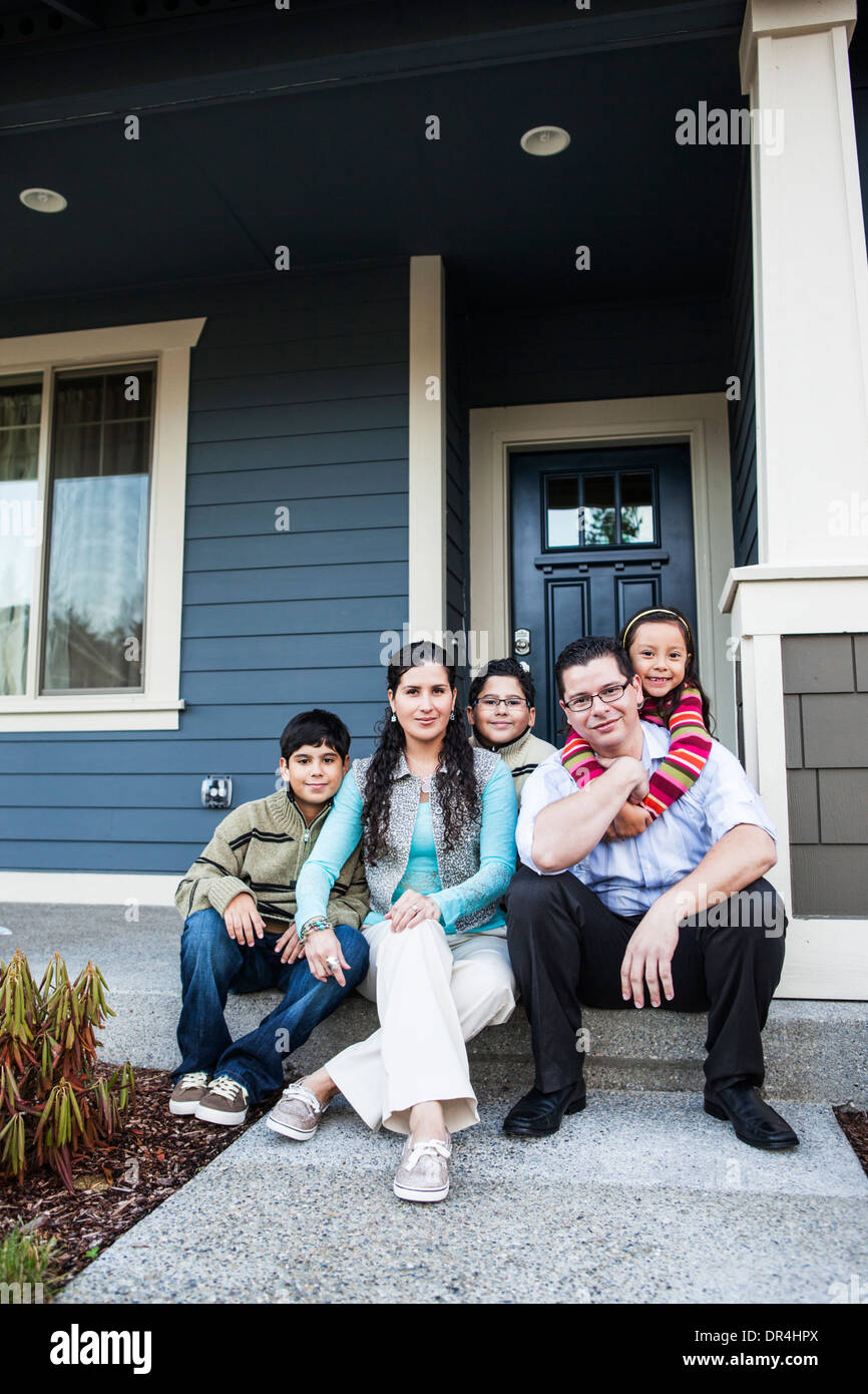 Family smiling sur avant stoop Banque D'Images