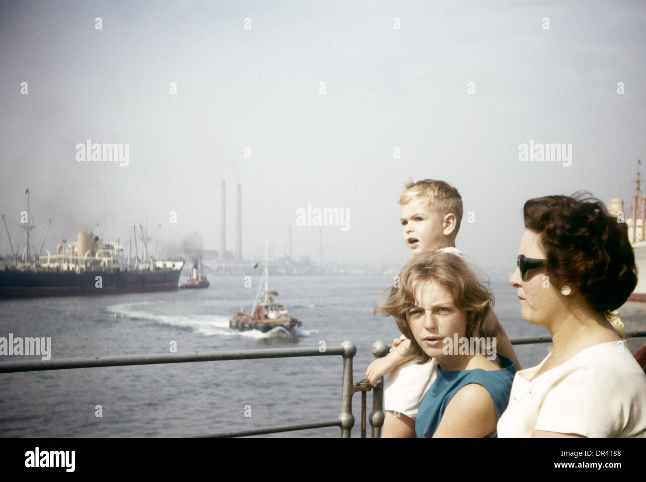 Un stand à la famille garde-corps regardant voyage sur la Tamise à Gravesend pendant l'été, au début des années 1960. Banque D'Images