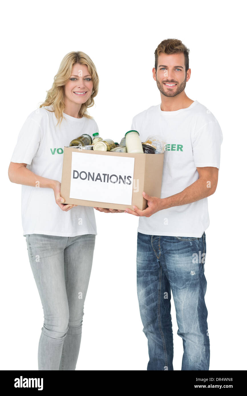 Smiling young couple carrying case don Banque D'Images