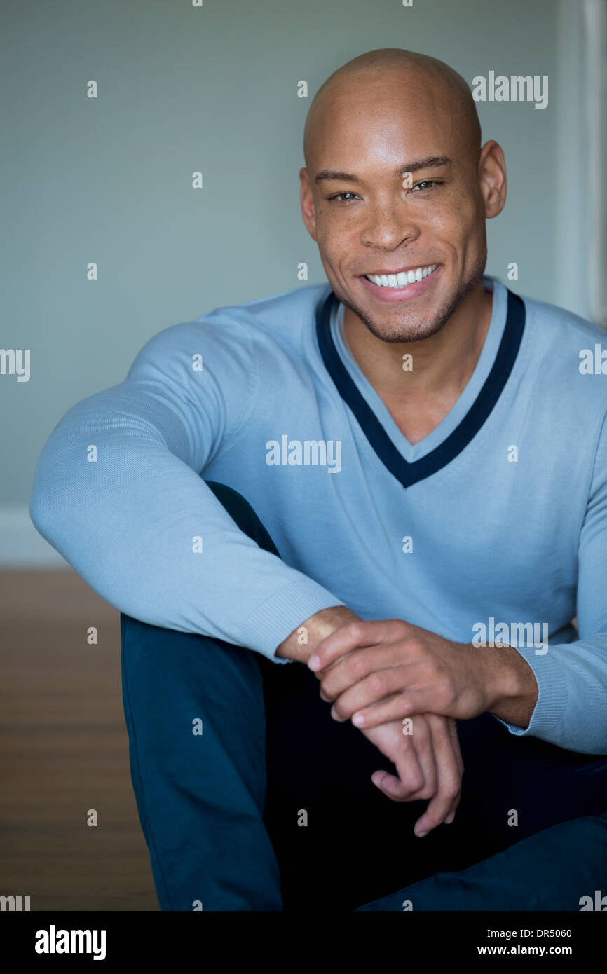 Mixed Race man in V-neck sweater Banque D'Images