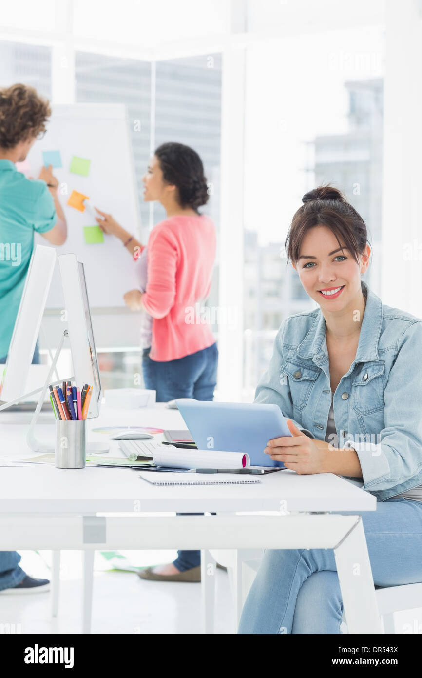 Casual woman using digital tablet in office derrière avec des collègues Banque D'Images