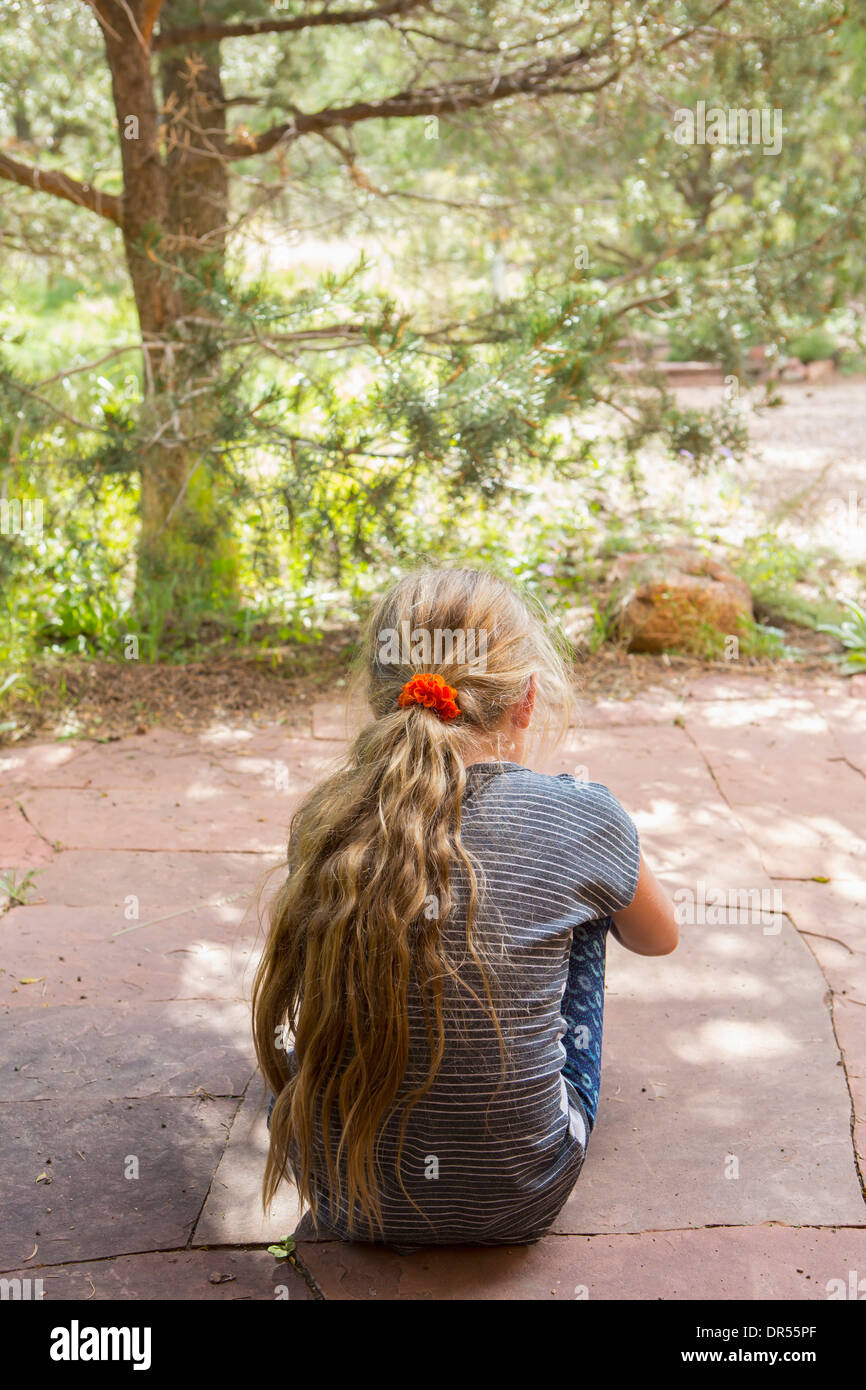 Caucasian girl sitting outdoors Banque D'Images