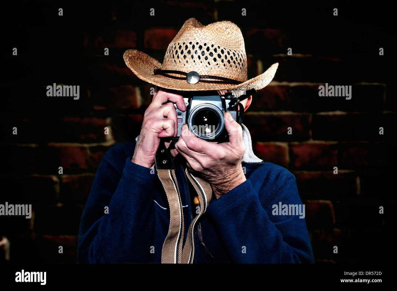 Man wearing cowboy hat photographier avec appareil photo vintage Banque D'Images