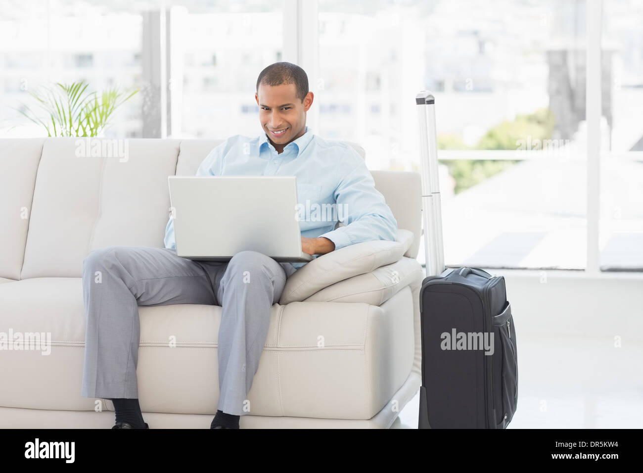 Happy businessman using laptop en attente de partir en voyage d'affaires Banque D'Images