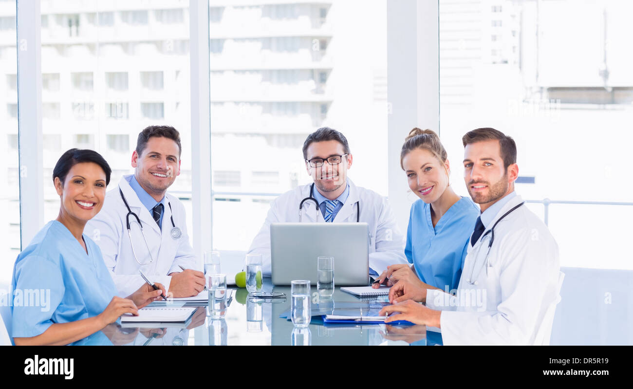 Smiling medical team autour de desk in office Banque D'Images