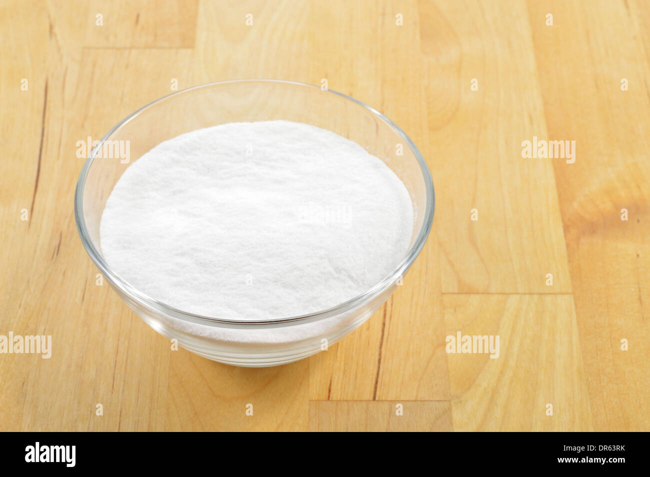 Close-up de bicarbonate de soude dans un bol en verre contre l'arrière-plan de table en bois. Le bicarbonate de soude. Banque D'Images