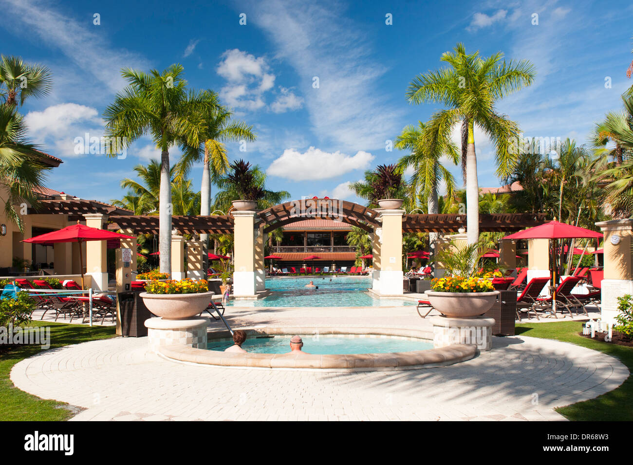 USA Florida PGA National Golf Course Palm Beach Gardens Hotel & piscine arbres parasols parasol rouge Banque D'Images