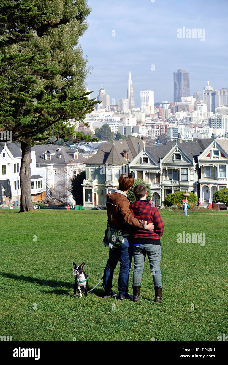 Couple de touristes et de chien donnent sur Victoria et san francisco skyline dans Alamo Square San Francisco Banque D'Images