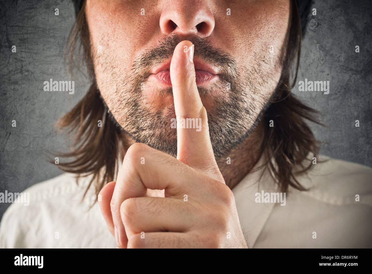 Businessman making hush geste, doigt sur la bouche pour le silence. Banque D'Images