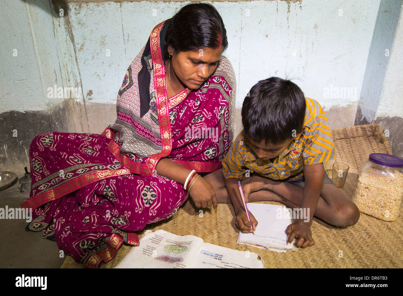 Un projet du WWF à fournir de l'électricité à une île isolée dans les Sunderbans, une zone de basse altitude du delta du Gange dans l'Est de l'Inde, qui est très vulnérable à la montée du niveau de la mer. Avant ce projet, les agriculteurs de subsistance n'avait pas accès à l'électricité. Le projet a permis à ce garçon à faire ses devoirs, qu'il peut maintenant voir par la lumière électrique. Avant le projet leur maison aurait été éclairée par les lampes à pétrole. plus de 1 million de femmes et d'enfants meurent chaque année en Inde à partir de l'inhalation de vapeurs de kérosène. Banque D'Images