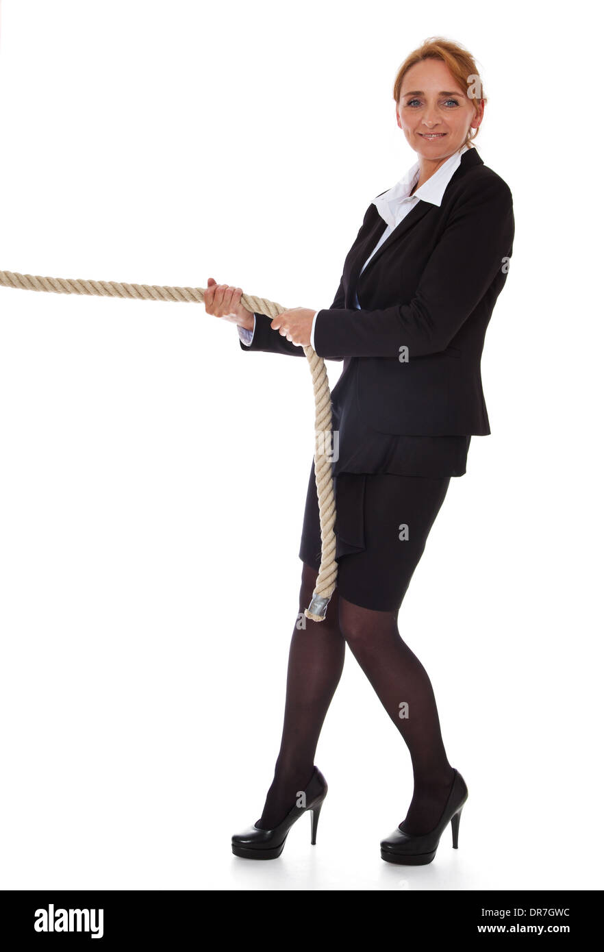 Businesswoman pulling rope. Le tout sur fond blanc. Banque D'Images