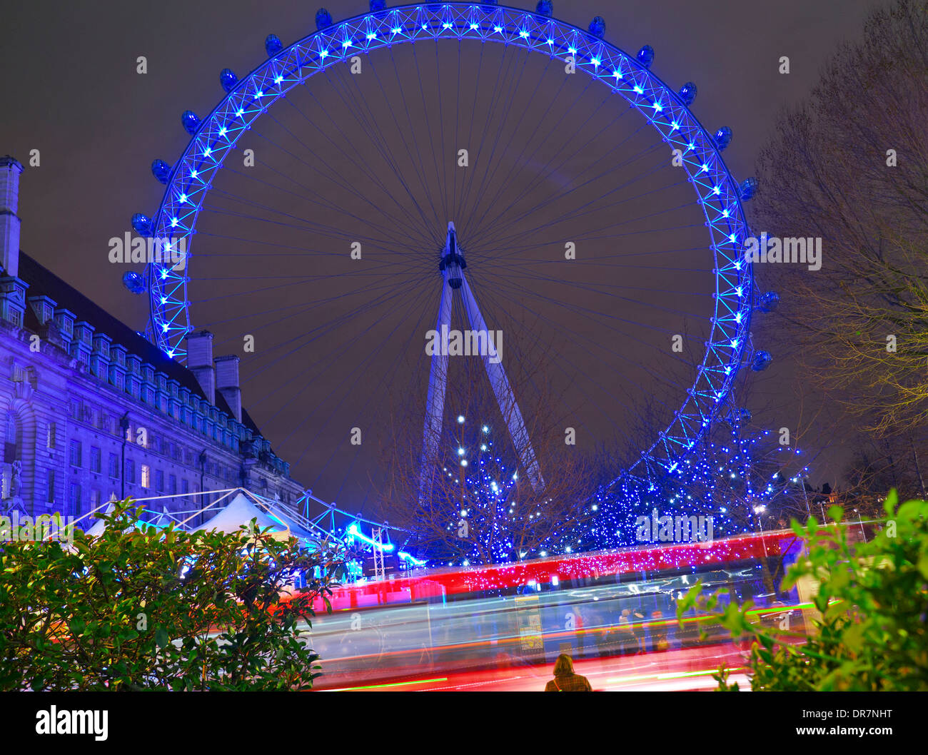 Le London Eye de nuit avec London bus rouge brouillée passant en premier plan South Bank de Londres, Angleterre, Royaume-Uni Banque D'Images