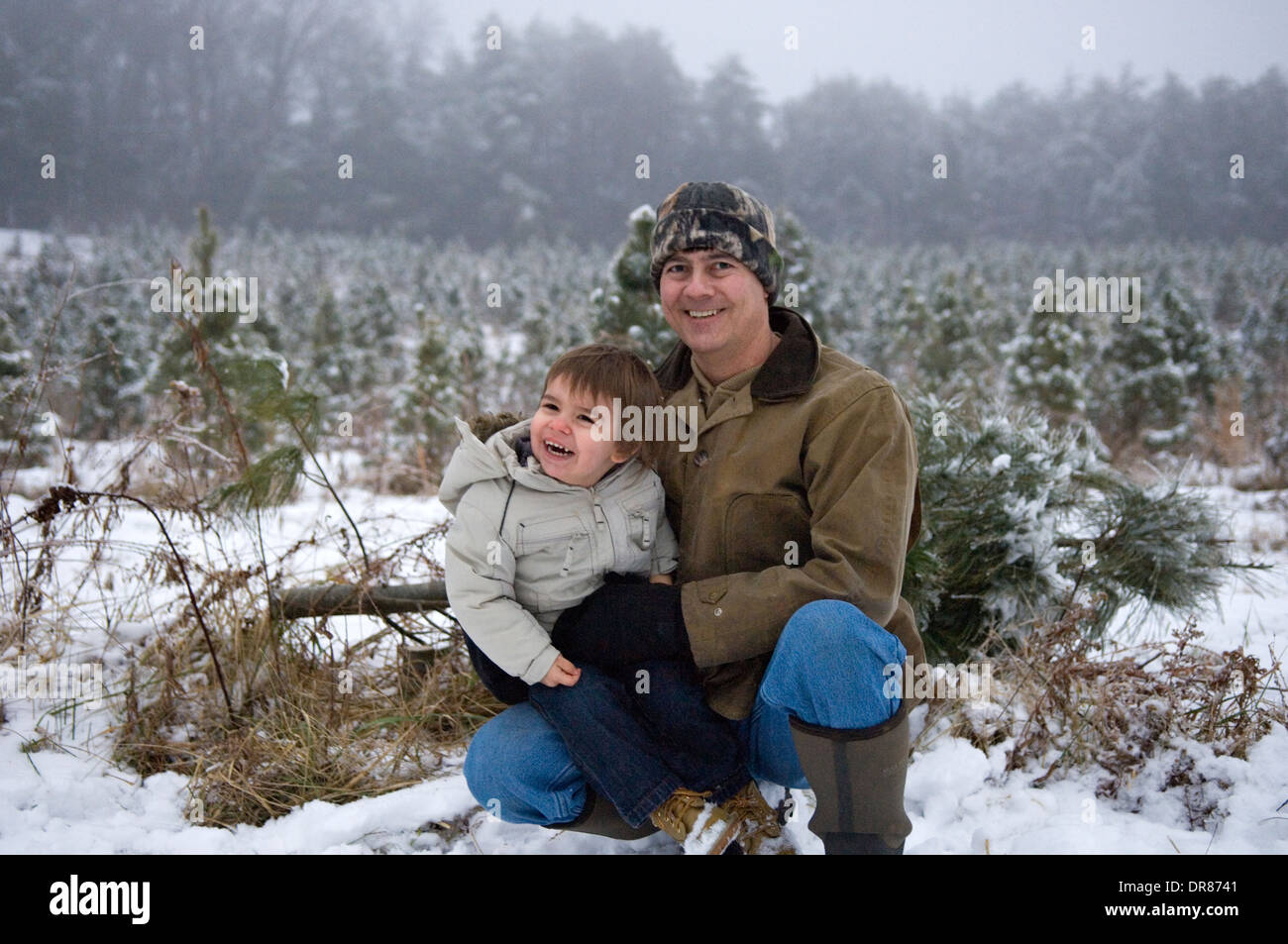 Grand-père et petit-fils posant pour la photo lors de sortie à couper un arbre de Noël dans le sud de l'Indiana Banque D'Images