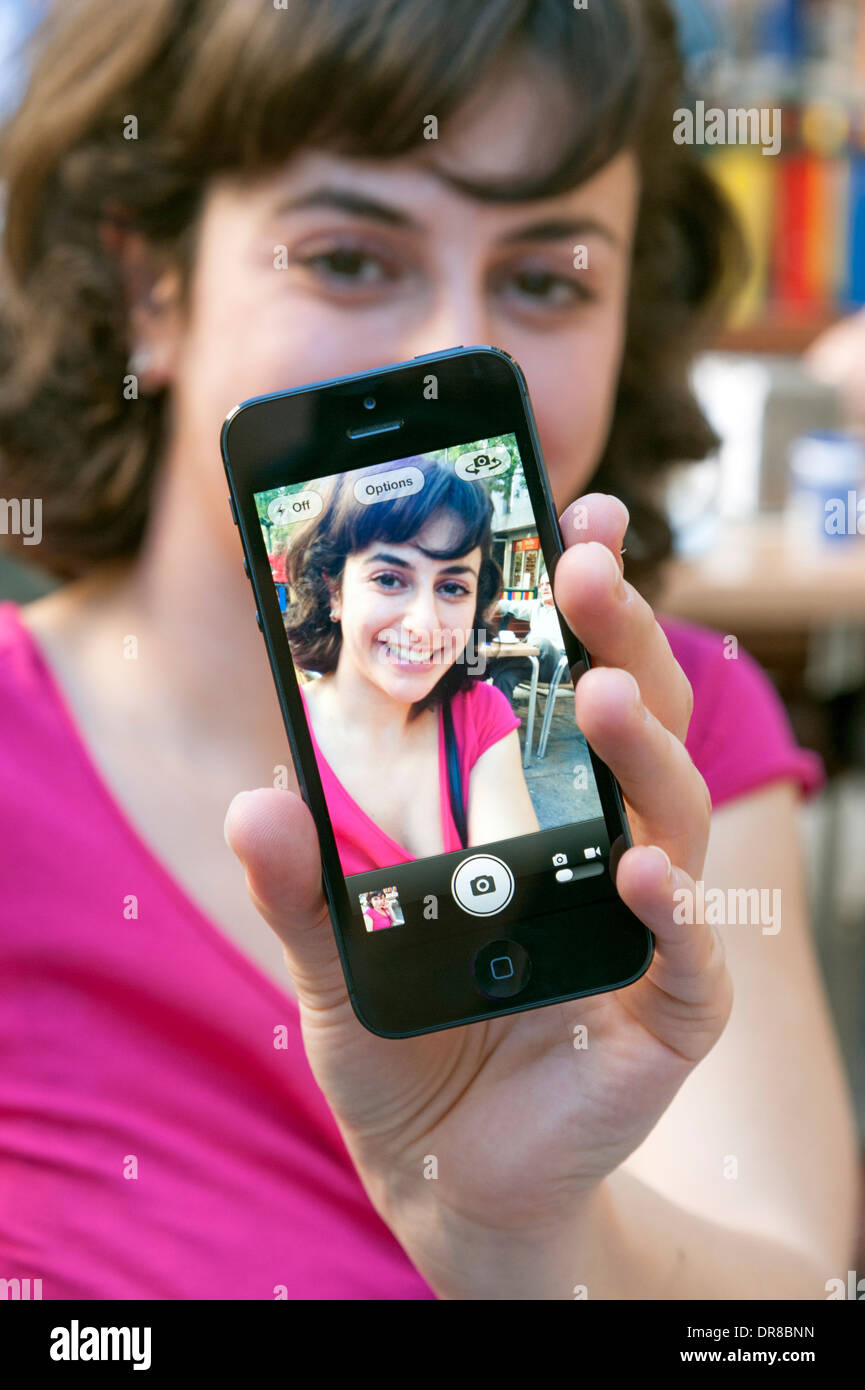 Jeune femme tenant un sur un iPhone d'Apple selfies Banque D'Images