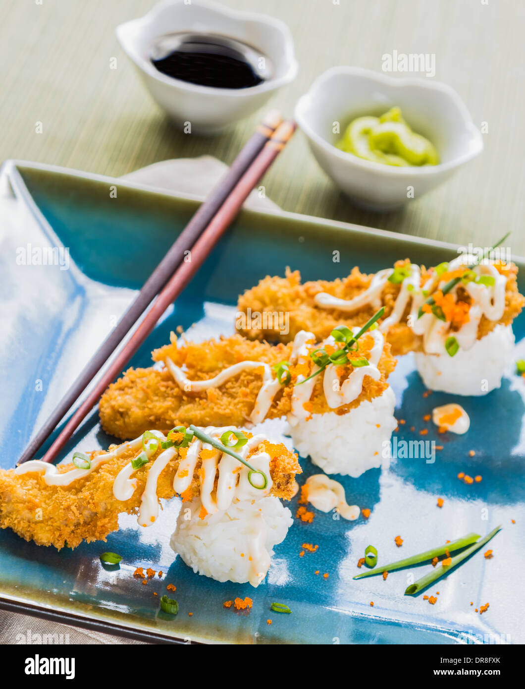 Thon ahi pané frit sur une boule de riz, arrosé de masago, mayonnaise et parsemé d'oignons verts et masago Banque D'Images