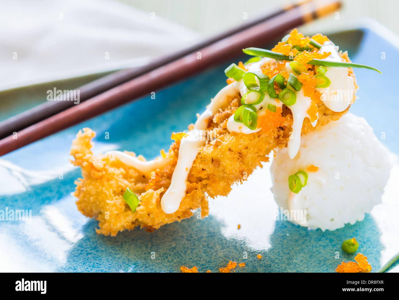 Thon ahi pané frit sur une boule de riz, arrosé de masago, mayonnaise et parsemé d'oignons verts et masago Banque D'Images