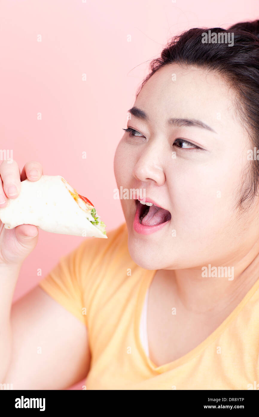 Une femme rondelette à propos de manger sandwich wrap Banque D'Images