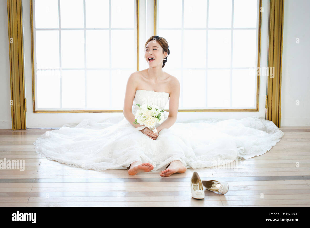 Une femme assise sur le sol avec robe de mariage sur Banque D'Images