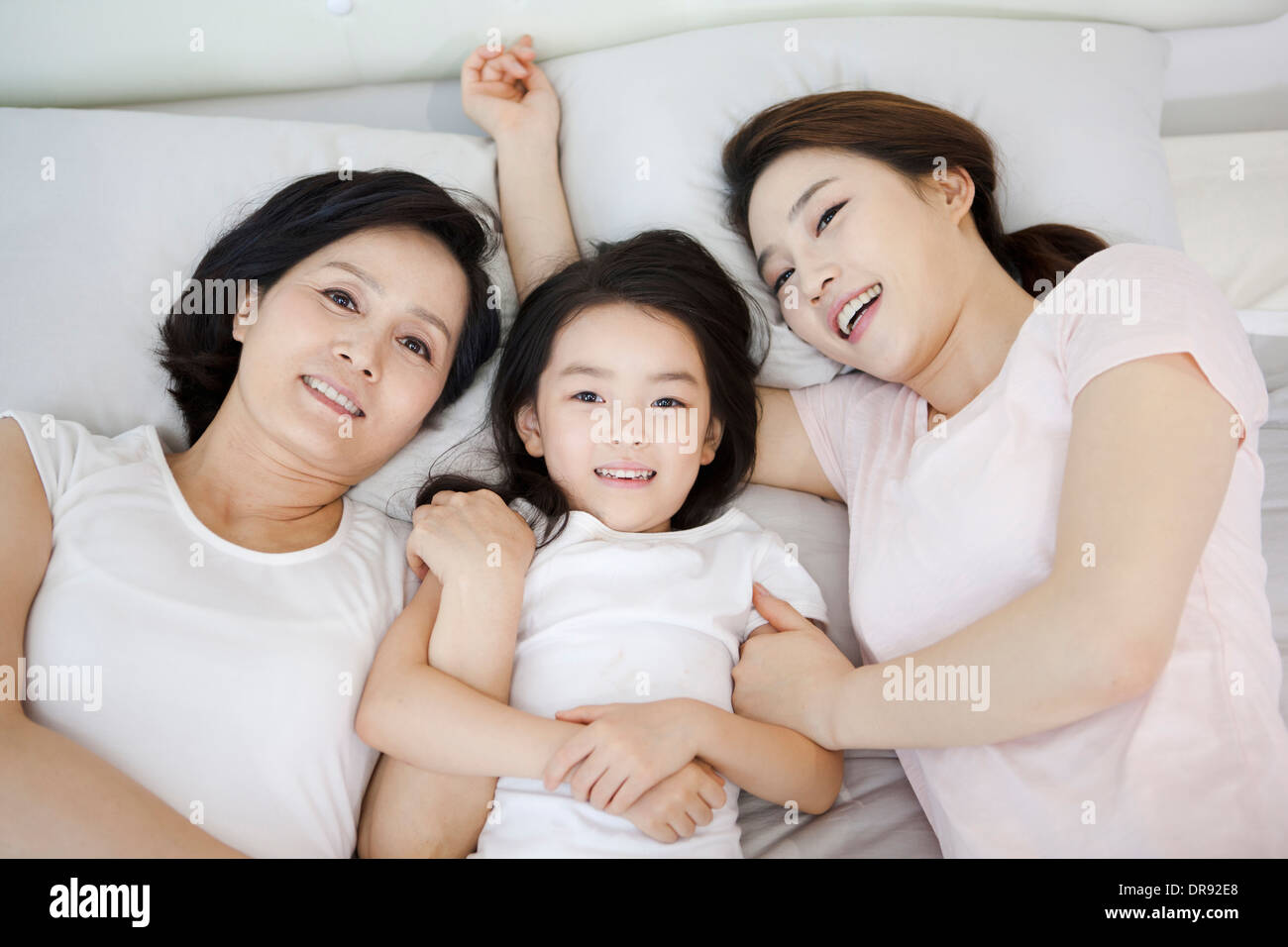 Une femme avec sa fille et petite fille sur un lit Banque D'Images