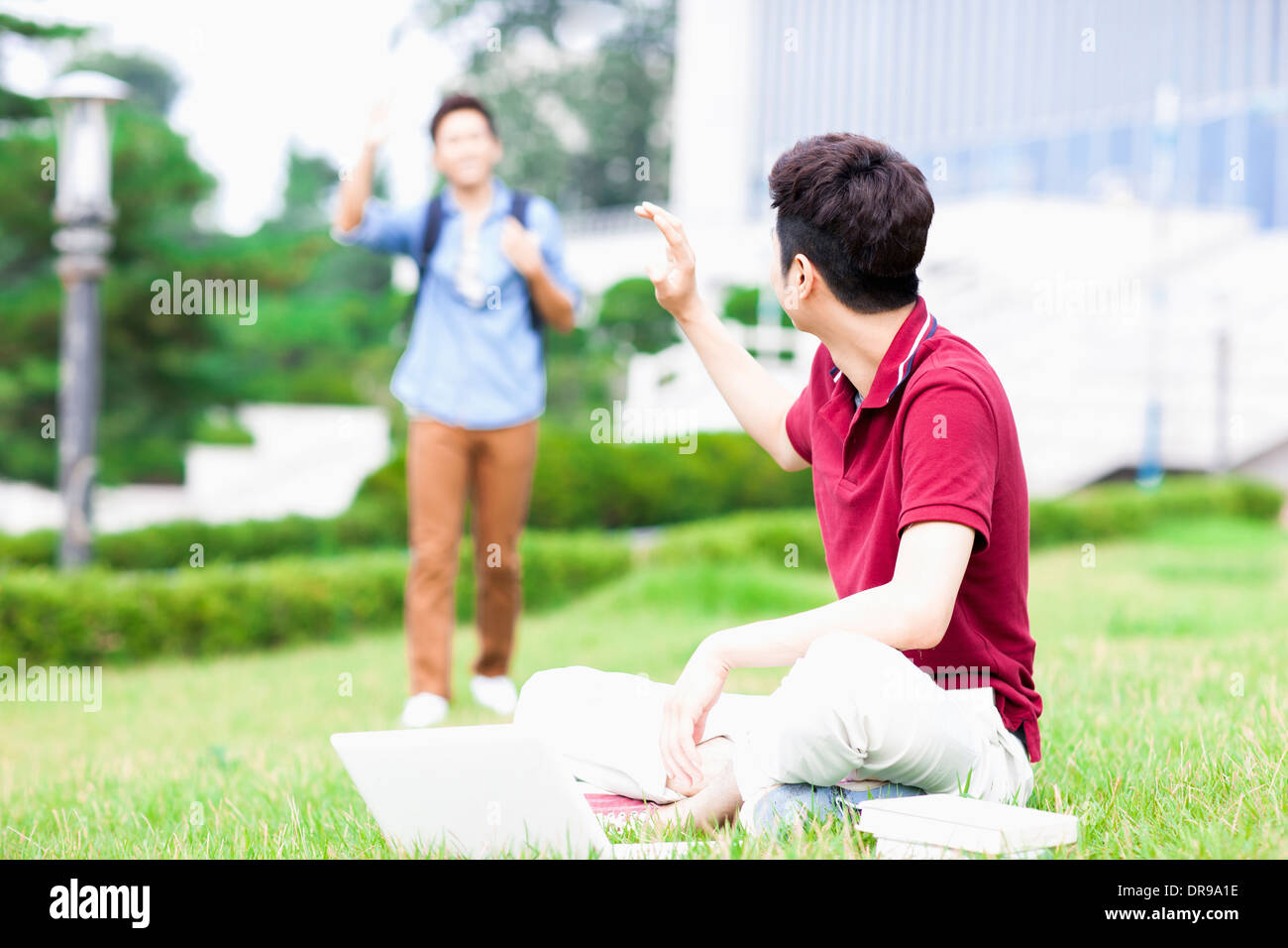 Un homme assis sur l'herbe un message d'ami Banque D'Images