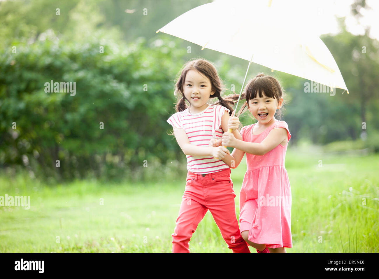 Deux filles marcher avec un parapluie Banque D'Images