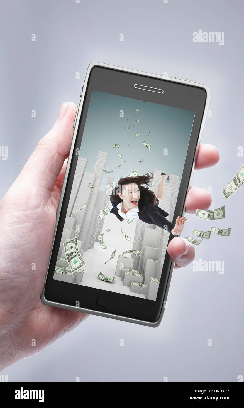 Une main tenant un téléphone portable avec une femme d'intérieur avec de l'argent Banque D'Images