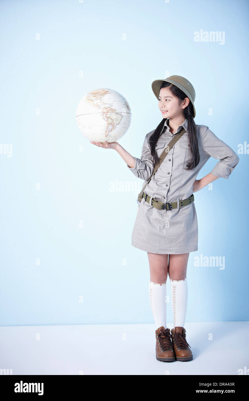 A girl holding a globe habillé comme un explorateur Banque D'Images