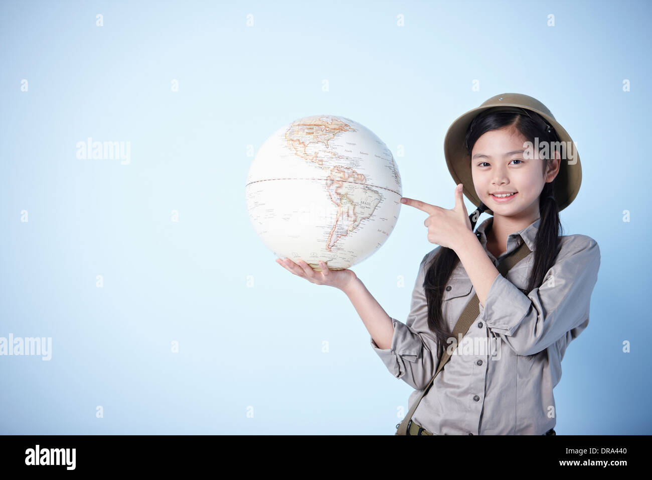 A girl holding a globe habillé comme un explorateur Banque D'Images