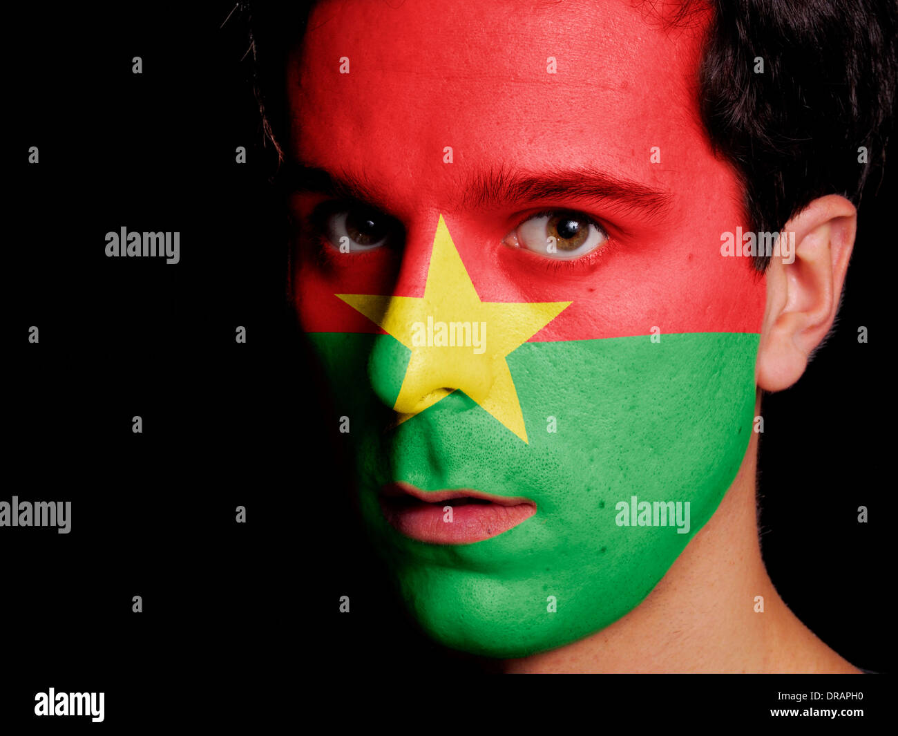 Pavillon de l'Burkina Faso peint sur un visage d'un jeune homme Banque D'Images