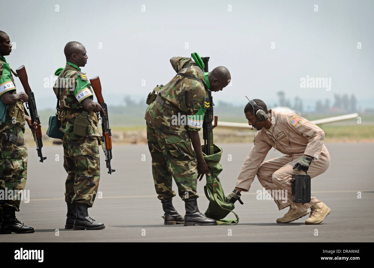 Des soldats rwandais ont leurs armes inspectées avant de monter à bord d'un US Air Force C-17 Globemaster III à l'appui de l'Union africaine un effort pour réprimer la violence en République centrafricaine, 19 janvier 2014 à Kigali, Rwanda. Banque D'Images