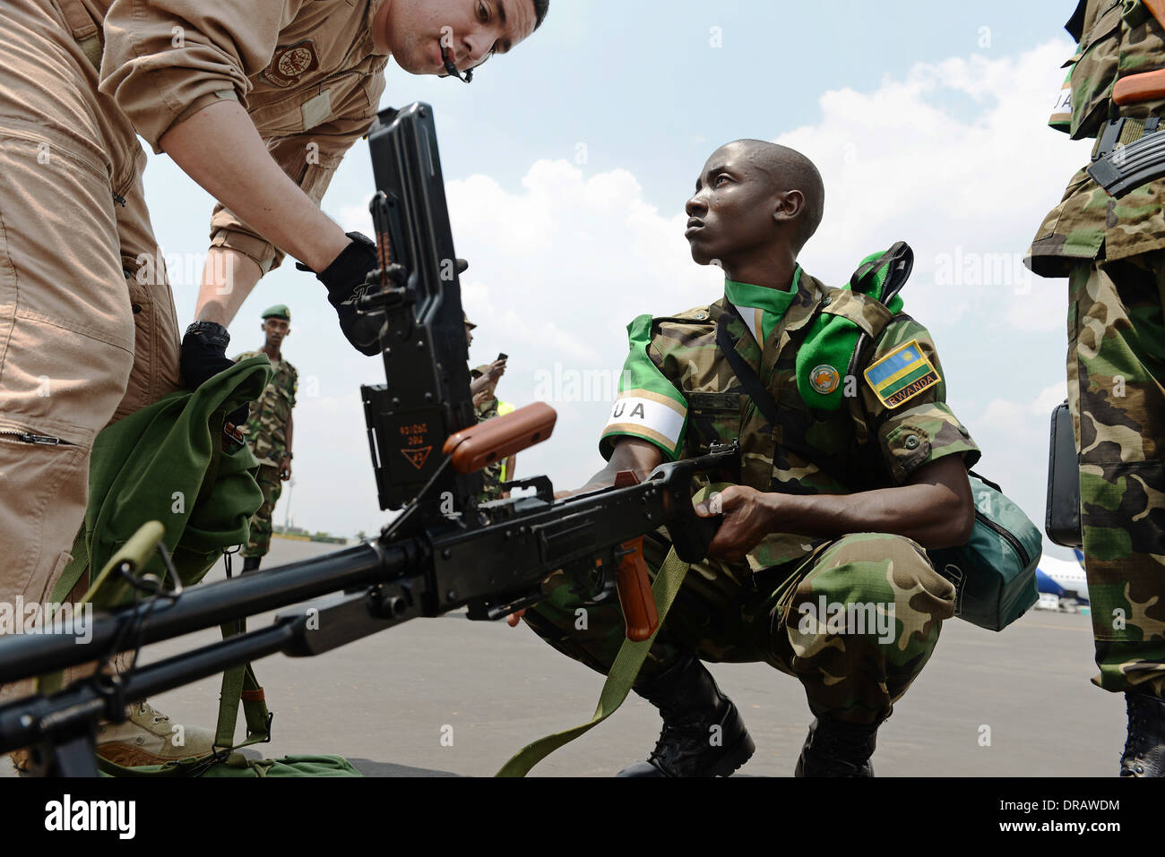 Des soldats rwandais ont leurs armes inspectées avant de monter à bord d'un US Air Force C-17 Globemaster III à l'appui de l'Union africaine un effort pour réprimer la violence en République centrafricaine, 19 janvier 2014 à Kigali, Rwanda. Banque D'Images