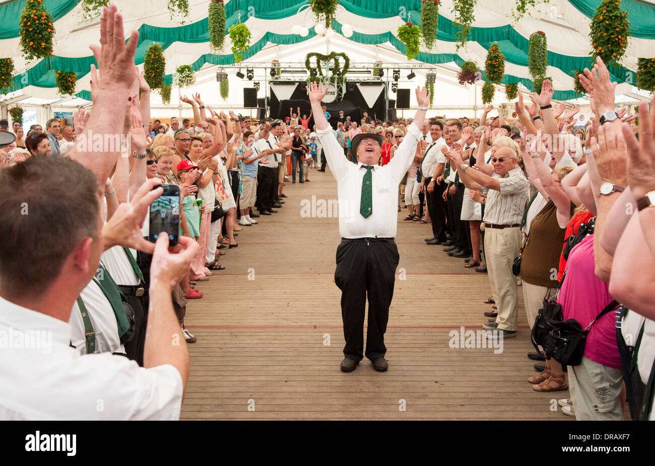 Les visiteurs d'un festival de tireurs d'applaudir leur nouveau roi, les tireurs qui ont tiré le tir vers le bas. d'oiseaux en bois Banque D'Images