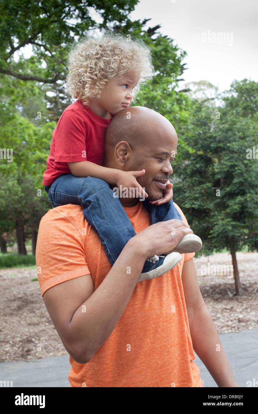Happy father carrying son on shoulders Banque D'Images